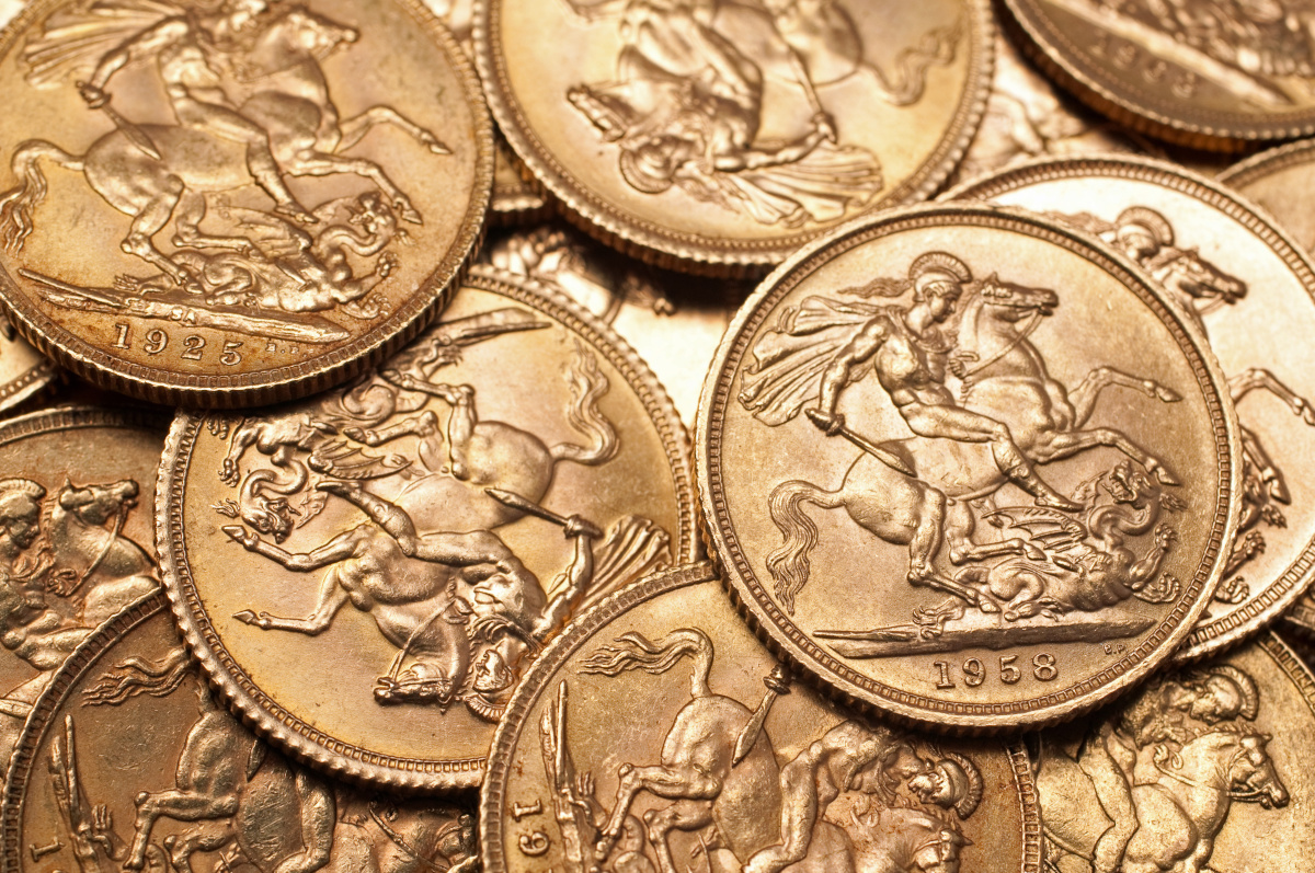 Sovereign coins from different years lying on top of each other, with the Saint George and the Dragon design motif facing upwards